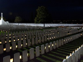 FILE - In this Friday, Oct. 17, 2014, file photo, World War I graves are illuminated by candles at the Tyne Cot Commonwealth cemetery in Zonnebeke, Belgium. France and Belgium are urging UNESCO to designate scores of their World War I memorials and cemeteries as World Heritage sites as the centennial remembrance of the 1914-1918 war nears its end.