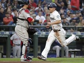 Seattle Mariners' Kyle Seager, right, scores as Boston Red Sox catcher Christian Vazquez waits for the ball during the fifth inning of a baseball game Thursday, June 14, 2018, in Seattle.