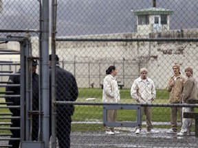 FILE - In this file photo taken Jan. 28, 2016, inmates mingle in a recreation yard in view of guards, left, at the Monroe Correctional Complex in Monroe, Wash. A federal judge has ordered the Washington Department of Corrections to provide nighttime meals to all Muslim inmates who have been fasting during the month of Ramadan, after several said prison officials refused to do so. The Council on American-Islamic Relations sued the department on behalf of four prisoners at the Washington State Reformatory in Monroe, saying the men had lost an average of more than 20 pounds since Ramadan began in mid-May.