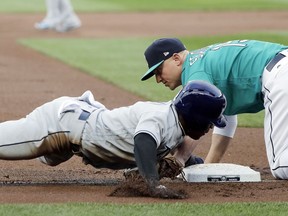 Tampa Bay Rays' Mallex Smith, left, is caught stealing third with a tag by Seattle Mariners third baseman Kyle Seager, right, during the first inning of a baseball game Friday, June 1, 2018, in Seattle.