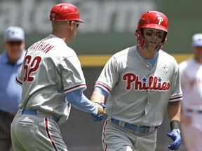 Philadelphia Phillies' Rhys Hoskins, right, is congratulated by Dusty Wathan after hitting a two-run home run during the first inning of a baseball game against the Milwaukee Brewers, Sunday, June 17, 2018, in Milwaukee.