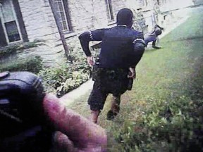 FILE – This June 14, 2017, file frame displayed on a screen during the trial of Milwaukee police officer Dominique Heaggan-Brown in Milwaukee shows Milwaukee Police Department body camera video of Heaggan-Brown, center, running behind Sylville Smith, right, after a routine traffic stop Aug. 23, 2016, that turned fatal. Heaggan-Brown was acquitted of first-degree reckless homicide in Smith's death, one of the high-profile cases in recent years in which police were charged with shootings of black people.