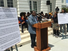 Winston Clarke, the father of a Duke Ellington High School junior, speaks during a May 23, 2018, news conference in front of the school in Washington. Parents at the prestigious performing arts public school are in a fight with the office of the school superintendent, which charges that dozens of Ellington families have faked District of Columbia residency in order to attend the school without paying tuition. The Ellington controversy is just the latest in a string of rapid-fire scandals that has damaged the reputation of the Washington public school system.