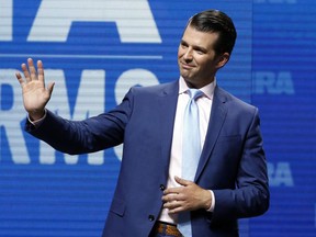 FILE - In this May 4, 2018, file photo, Donald Trump Jr., waves from the stage at the National Rifle Association in Dallas. A dispute between two political families escalated June 19 as Donald Trump Jr. canceled plans to raise money for George P. Bush, the eldest son of former Florida Gov. Jeb Bush. Trump Jr. decided to withdraw from a fundraiser after Jeb Bush criticized the president's immigration policy, according to two people with direct knowledge of the situation who spoke on condition of anonymity.