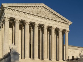 FILE - In this April 20, 2018, file photo, the Supreme Court is seen in Washington.  The Supreme Court is leaving in place a ruling for American Express in a lawsuit over rules it imposes on merchants who accept its cards. The high court ruled 5-4 Monday in favor of American Express.