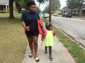In this May 17, 2018 photo, Shannon Brown, 29, walks with her four-year-old daughter, Sai-Mya, in Charleston, S.C.  Brown lives in public housing and could face a steep increase under a HUD proposal that would raise rents for millions of low-income individuals and families.