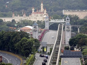 FILE - In this June 12, 2018, file photo, a car carrying United States President Donald Trump enters Sentosa island where the summit between him and North Korean leader Kim Jong Un will take place at the Capella Hotel in Sentosa, Singapore. As Trump was heading to Singapore, a State Department diplomatic security agent who was part of the advance team reported hearing an unusual sound he believed was similar to what was experienced by U.S. diplomats in Cuba and China who later became ill. The agent immediately underwent medical screening. It turned out to be a false alarm, but the rapid response showed Washington's concern over the mysterious health incidents.