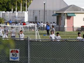 Immigrant children play outside a former Job Corps site that now houses them, Monday, June 18, 2018, in Homestead, Fla. It is not known if the children crossed the border as unaccompanied minors or were separated from family members. Wrenching scenes of migrant children being separated from their parents at the southern border are roiling campaigns ahead of midterm elections, emboldening Democrats on the often-fraught issue of immigration