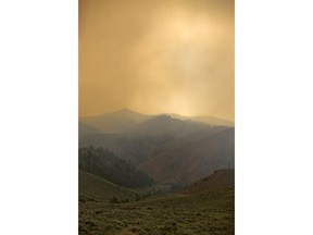 Smoke from the Badger Creek Fire drifts through the air, Monday, June 11, 2018, as seen from Highway 10, near Woods Landing, Wyo.