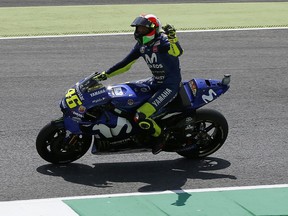 Yamaha rider Valentino Rossi, of Italy, celebrates after setting the pole position during the qualifying session for Sunday's Italian Moto GP grand prix at the Mugello circuit, in Scarperia, Italy, Saturday, June 2, 2018.