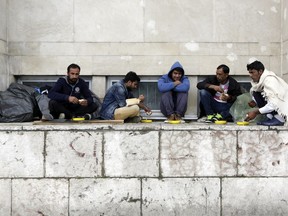 Migrants from Pakistan have their lunch in front of a railway station in Sarajevo, Bosnia, on Tuesday, June 19, 2018. Hundreds of migrants have been camping at the railway station building in the Bosnian capital of Sarajevo waiting for opportunity to get to Croatia and Western Europe.