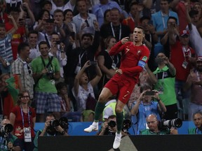 Portugal's Cristiano Ronaldo leaps as he celebrates after scoring his sides 1st goal form a penalty during the group B match between Portugal and Spain at the 2018 soccer World Cup in the Fisht Stadium in Sochi, Russia, Friday, June 15, 2018.