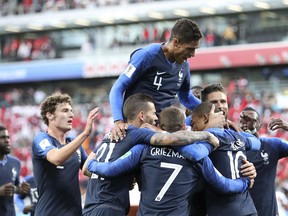 France's Kylian Mbappe, (10), is mobbed by teammates after scoring the opening goal of the game during the group C match between France and Peru at the 2018 soccer World Cup in the Yekaterinburg Arena in Yekaterinburg, Russia, Thursday, June 21, 2018.
