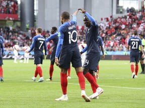 France's Blaise Matuidi, right holds up France's Kylian Mbappe's hand as they celebrate after Mbappe scored the opening goal of the game during the group C match between France and Peru at the 2018 soccer World Cup in the Yekaterinburg Arena in Yekaterinburg, Russia, Thursday, June 21, 2018.