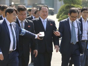 The head of the North Korean delegation Ri Son Gwon, center, talks with South Korean reporters as he arrives to meet with South Korean Unification Minister Cho Myoung-gyon at the southern side of Panmunjom in the Demilitarized Zone, South Korea, Friday, June 1, 2018. (Korea Pool via AP)