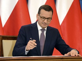 Polish Prime Minister Mateusz Morawiecki signs the Joint Declaration of Prime Ministers of the State of Israel and the Republic of Poland, in his chancellery in Warsaw, Poland, Wednesday, June 27, 2018. Poland suddenly backtracked Wednesday on a disputed Holocaust speech law, scrapping the threat of prison for attributing Nazi crimes to the Polish nation. The original law, which was passed five months earlier, had supposedly been aimed at defending the country's "good name" -- but mostly had the opposite effect.