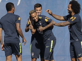 Brazil's Marcelo, right, and Philippe Coutinho, back, joke with teammate Neymar, during a training session, in Sochi, Russia, Sunday, June 24, 2018. Brazil will face Serbia on June 27 in the group E for the soccer World Cup.