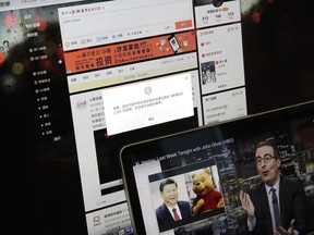 A screen shows a failure message saying a post could not be sent because "the content contains information that violates relevant laws and regulations" on Sina Weibo next to a smaller computer screen showing a "Last Week Tonight" HBO show's host John Oliver with a photo of Chinese President Xi Jinping and Winnie the Pooh, in Beijing, Friday, June 22, 2018.