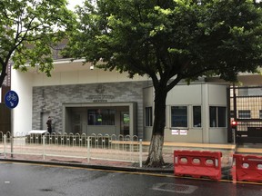 A security person walks outside the U.S. consulate building in Guangzhou in south China's Guangdong province, Thursday, June 7, 2018. The United States has evacuated several more government workers out of the southern Chinese city of Guangzhou after medical testing revealed they might have been affected by unexplained health incidents that have already hurt U.S. personnel in Cuba, the State Department said Wednesday. State Department spokeswoman Heather Nauert said "a number of individuals" have been brought to the U.S. They are in addition to a U.S. worker in Guangzhou who was evacuated earlier, as the Trump administration had already disclosed.