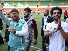 In this photo taken on Sunday, June 10, 2018, Egyptian national soccer team player and Liverpool's star striker Mohammed Salah, right, and Chechen regional leader Ramzan Kadyrov, greets soccer fans as they arrive to attend the Egypt national soccer team training session in Grozny, Russia. Egyptian national soccer team will compete in the 2018 World Cup in Russia. The 21st World Cup begins on Thursday, June 14, 2018, when host Russia takes on Saudi Arabia. (AP Photo)