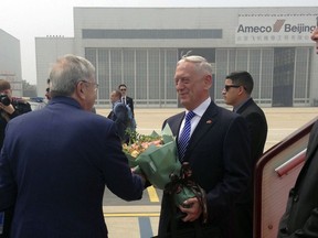 U.S. Defense Secretary Jim Mattis, center, is greeted as he arrives at Beijing Capital International Airport in Beijing, Tuesday, June 26, 2018. Mattis laid out plans for a less contentious, more open dialogue with Chinese leaders as he travels to Asia, less than a month after he slammed Beijing at an international conference for its militarization of islands in the South China Sea.