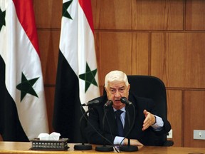 In this photo released by the Syrian official news agency SANA, Syrian Foreign Minister Walid al-Moallem speaks during a press conference in Damascus, Syria, Saturday, June 2, 2018. Al-Moallem said Iranian military advisers are embedded with Syrian troops but Tehran has no combat forces or fixed bases in the country. (SANA via AP)