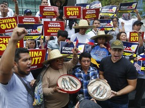 Protesters shout slogans while displaying small catch during a rally at the Chinese Consulate in the financial district of Makati city to protest alleged continued seizure of catches of Filipino fishermen at a disputed shoal in the South China Sea despite a protest by the Philippines following an earlier incident Monday, June, 11, 2018 east of Manila, Philippines. The Philippines expressed concern to China in a meeting in Manila in February after receiving a report of Chinese coast guard personnel boarding a Filipino fishing boat at Scarborough Shoal and taking some of its catch, officials said.