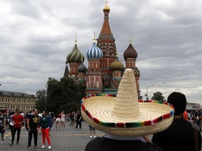 A supporter from Mexico looks at the Saint Basil's Cathedral on the Red Square during the 2018 soccer World Cup in Moscow, Russia, Thursday, June 21, 2018.