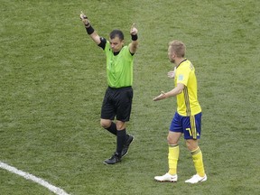 Referee Joel Aguilar of Salvador signals for video review during the group F match between Sweden and South Korea at the 2018 soccer World Cup in the Nizhny Novgorod stadium in Nizhny Novgorod, Russia, Monday, June 18, 2018.
