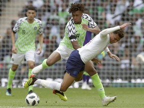 Nigeria's Alex Iwobi, center, duels for the ball with England's Dele Alli during a friendly soccer match between England and Nigeria at Wembley stadium in London, Saturday, June 2, 2018.