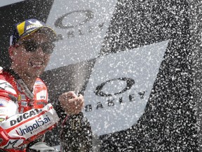 Spain's rider Jorge Lorenzo of the Ducati Team sprays champagne to celebrate his victory in the MotoGP race at the Italian Moto GP grand prix at the Mugello circuit, in Scarperia, Italy, Sunday, June 3, 2018.