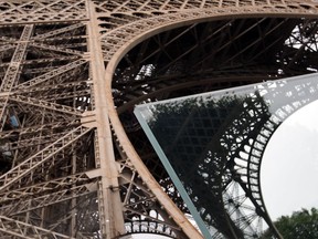 View of a new security bulletproof glass barrier under construction around the Eiffel Tower in Paris, France, Thursday, June 14, 2018. Paris authorities have started replacing the metal security fencing around the Eiffel Tower with a more visually appealing glass wall. The company operating the monument said see-through panels are being set up instead of the fences at the north and south of the famed monument that were installed for the Euro 2016 soccer event. Each panel is 3 meters high, over 6 centimeters thick and weighs 1.5 ton.