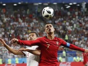 Portugal's Cristiano Ronaldo, right, and Iran's Omid Ebrahimi challenge for the ball during the group B match between Iran and Portugal at the 2018 soccer World Cup at the Mordovia Arena in Saransk, Russia, Monday, June 25, 2018.