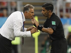 Referee Enrique Caceres from Paraguay, right, speaks to Iran head coach Carlos Queiroz during the group B match between Iran and Portugal at the 2018 soccer World Cup at the Mordovia Arena in Saransk, Russia, Monday, June 25, 2018.