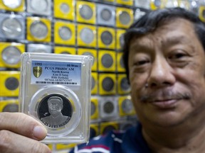 In this Monday, June 11, 2018, photo, rare coin collector and dealer Harry Ng displays a North Korean coin depicting Kim II Sung, founding leader of North Korea issued to commemorate his 80th Birthday in 1992 from his collection in Singapore. Stamped with images of "Eternal President" Kim Il Sung, national monuments or ballistic missiles, coins minted in North Korea are renowned among collectors for their scarcity, partly due to international sanctions that outlaw them from being auctioned.