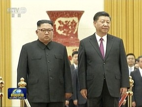 In this image taken from a video footage run by China's CCTV on June 19, 2018, via AP Video, Chinese President Xi Jinping, right, stands next to North Korean leader Kim Jong Un during a welcome ceremony at the Great Hall of the People in Beijing.