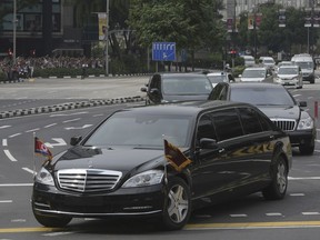 A limousine, front, with a North Korean flag believed to be carrying leader Kim Jong Un travels past Singapore's Orchard Road on its way to the St Regis Hotel as he arrives in Singapore on Sunday, June 10, 2018. Kim arrived Sunday in Singapore ahead of one of the most unusual summits in recent world history, a sit-down Tuesday with President Donald Trump.