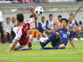 Japan's Shinji Kagawa, right, and Paraguay's Gustavo Gomez challenge for the ball during the friendly soccer match between Japan and Paraguay in the Tivoli Stadium in Innsbruck, Austria, on Tuesday, June 12, 2018.