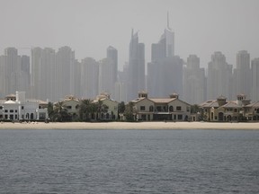 In this Wednesday, June 6, 2018 photo, Jumeirah Palm Island luxury villas are seen by their private beaches in Dubai, United Arab Emirates. A new report released Tuesday, June 12, 2018, by the Washington-based Center for Advanced Defense Studies, relying on leaked property data from the city-state, described Dubai's real-estate market as a haven for money launderers, terror financiers and drug traffickers sanctioned by the U.S. in recent years. Officials in Dubai said they could not comment on the report.