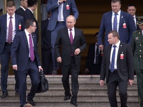 Russian President Vladimir Putin, center, leaves the Great Hall of the People after meeting with Chinese Premier Li Keqiang in Beijing, Friday, June 8, 2018. Putin is in China to attend the Shanghai Cooperation Organization (SCO) Summit in Qingdao.