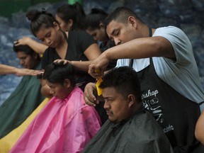 Student stylists trim the singed hair of residents who were burned during the powerful Volcan del Fuego or Volcano of Fire eruption, at a shelter near Escuintla, Guatemala, Wednesday, June 6, 2018. On an open-air patio at Murray D. Lincoln school, several displaced people sat on plastic chairs covered by aprons as the volunteers attended to them.