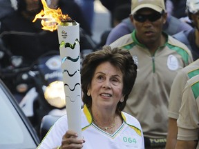 CORRECTS YEAR PHOTO TAKEN - FILE- In this July 24, 2016 file photo the former No. 1-ranked tennis player Maria Esther Bueno carries the Rio 2016 Olympic torch during the torch relay in Sao Paulo, Brazil. The Brazilian "queen" of tennis, who won three Wimbledon and four US championship singles titles, died Friday,June 8, 2018, in Sao Paulo. She had been suffering from mouth cancer since last year and was hospitalized in May.