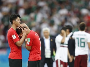 South Korea's Son Heung-min, left, consoles teammate Hwang Hee-chan at the end of the group F match between Mexico and South Korea at the 2018 soccer World Cup in the Rostov Arena in Rostov-on-Don, Russia, Saturday, June 23, 2018. Mexico won 2-1.
