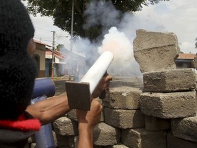 An opponent to the government of Nicaraguan President Daniel Ortega fires a homemade mortar at the police from a barricade, as the government forces enter the city in Masaya, Nicaragua, Tuesday, June 19, 2018. As the police forced its way into Masaya, Nicaragua's Roman Catholic hierarchy has suspended on Monday, a dialogue with the government aimed at ending a two-month political crisis.