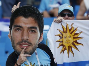 Uruguay's fan holds a portrait of Uruguay's Luis Suarez as he waits for the group A match between Uruguay and Saudi Arabia at the 2018 soccer World Cup in Rostov Arena in Rostov-on-Don, Russia, Wednesday, June 20, 2018.