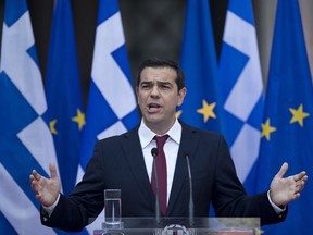 Greek Prime Minister Alexis Tsipras speaks to lawmakers from his left-led governing coalition in Athens, wearing a tie for the first time in more than three years, on Friday, June 22, 2018.  The left-wing politician had said at the beginning of his first term in office that he would only wear a tie when Greece had settled its debt problems, and in his speech, Tsipras hailed Friday's deal in Luxembourg as a landmark decision.