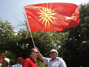 An opponent of the deal between Greece and Macedonia on the latter country's new name _ North Macedonia _ waves a Macedonian flag during a protest at the village Bitola on Sunday, June 17, 2018. The preliminary deal signed by the two countries' foreign ministers in the Prespes Lakes area, Greece, launches a long process that will last several months. If successful, it will end a decades-long dispute between neighbors Greece and Macedonia _ which will be renamed North Macedonia.