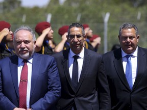 Israeli Defense Minister Avigdor Lieberman, left, Cypriot Defense Minister Savvas Angelides, center, and Greek Defense Mininister Panos Kammenos walk past a military police honor guard as they enter the Zenon Search and Rescue Coordination Center for a trilateral meeting in Larnaca, Cyprus, on Friday, June 22, 2018. Cyprus is playing host to the second such meeting of the three defense ministers that aims to bolster military and security cooperation between the three countries.