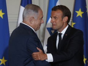 French President Emmanuel Macron and Israel's Prime Minister Benjamin Netanyahu shake hands as they attend a joint press conference at the Elysee Palace, in Paris, Tuesday, June 5, 2018. Netanyahu is meeting France's President Macron as part of his European tour, in an effort to rally support from allies over Iran.