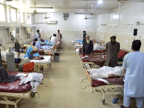 Injured men receive treatment at a hospital following a suicide attack in the city of Jalalabad east of Kabul, Afghanistan, Monday, June 11, 2018. A suicide bomber wounded at least 10 civilians when he struck near the education department in the eastern city of Jalalabad.